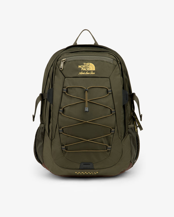 Olive green ALD / The North Face Borealis Backpack with yellow logo, bungee cord, side pockets, and top zipper.