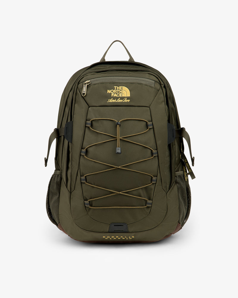 Olive green ALD / The North Face Borealis Backpack with yellow logo, bungee cord, side pockets, and top zipper.