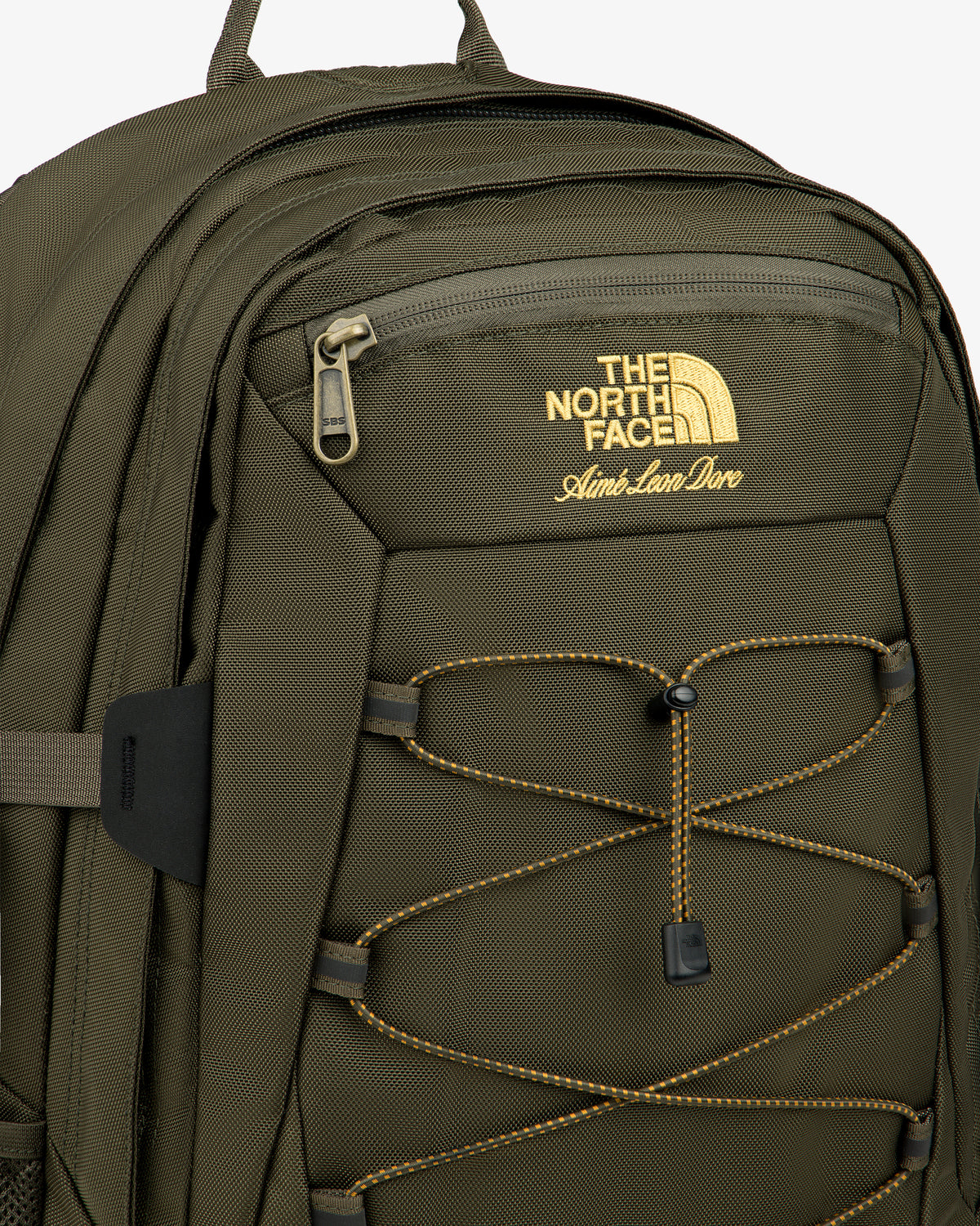 Olive green ALD/The North Face Borealis Backpack with yellow logo, front zipper pocket, and yellow bungee cord.