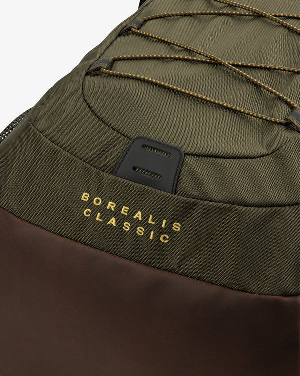 Close-up of olive-green ALD / The North Face Borealis Backpack with brown details and yellow-trimmed cords.