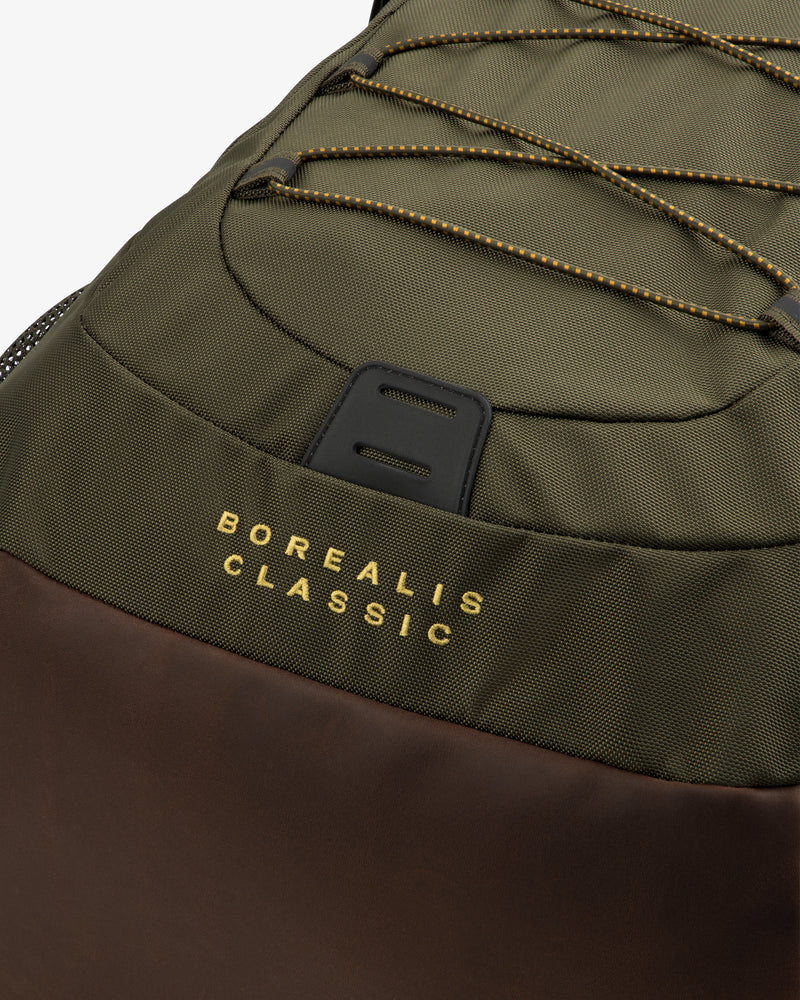 Close-up of olive-green ALD / The North Face Borealis Backpack with brown details and yellow-trimmed cords.