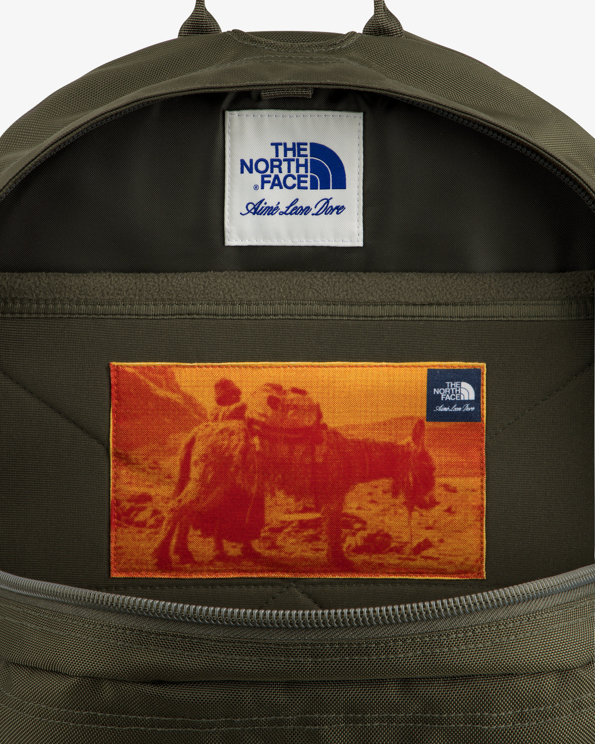 Open ALD / The North Face Borealis Backpack with a patch of two people on a camel and label above.