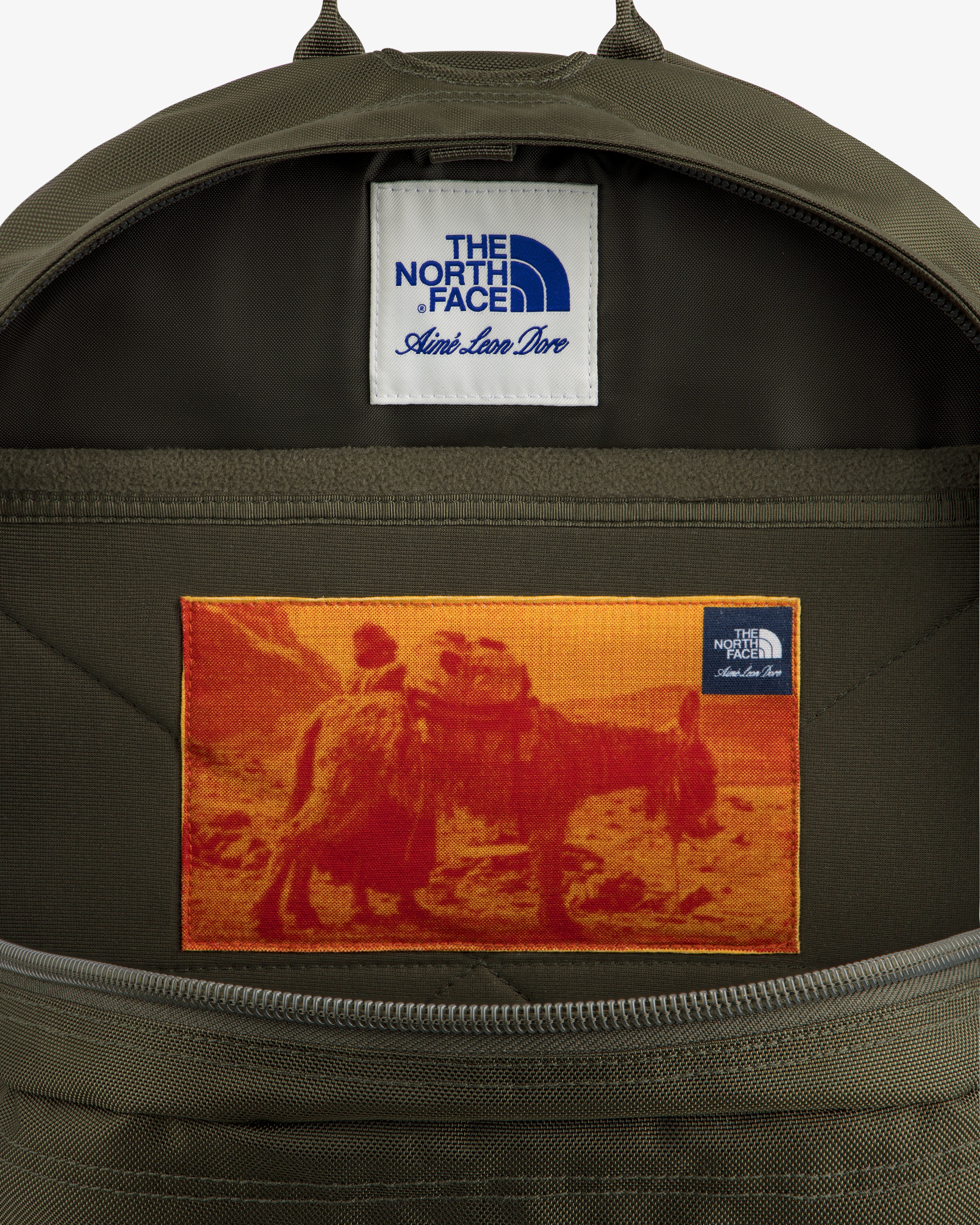 Open ALD / The North Face Borealis Backpack with a patch of two people on a camel and label above.