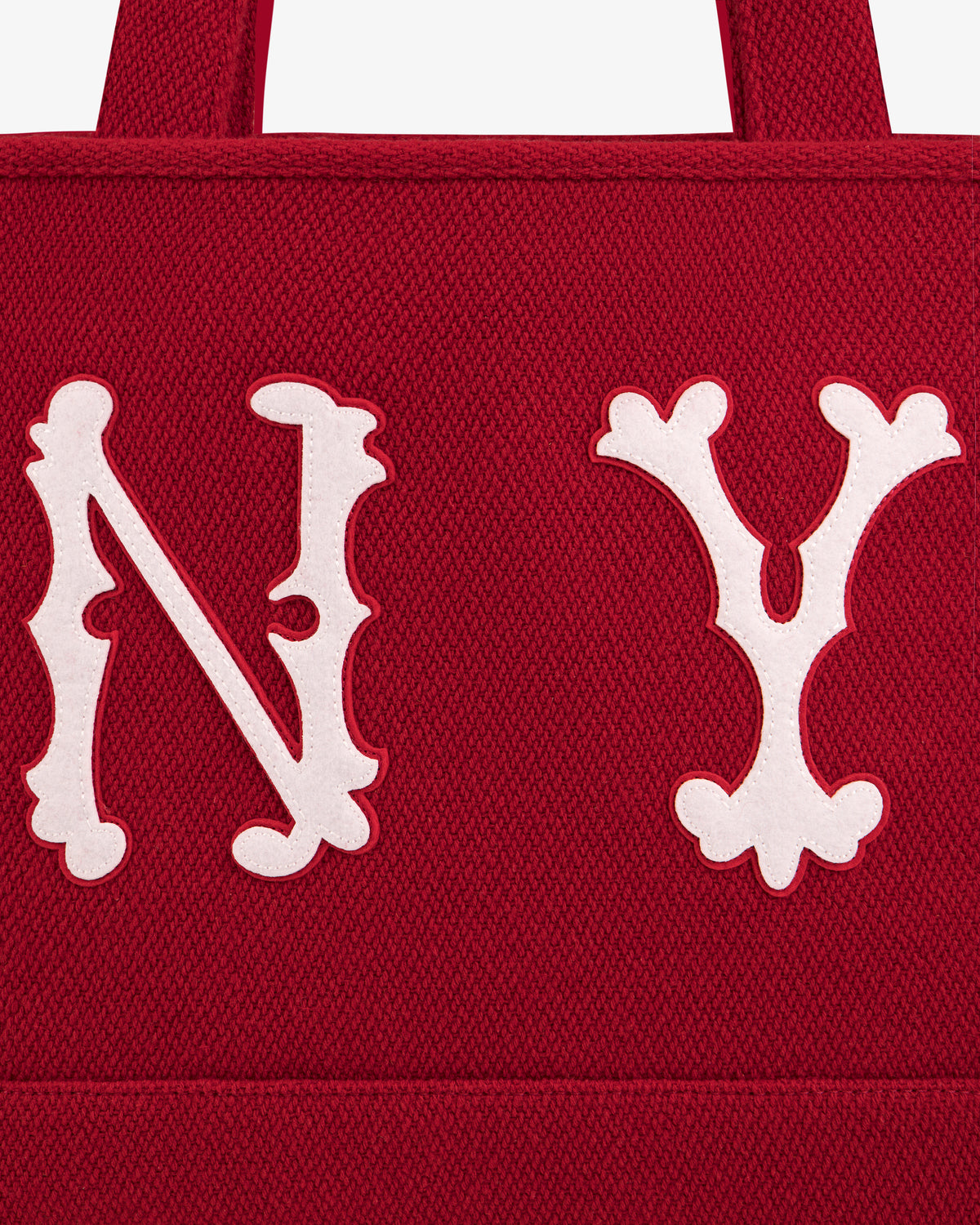 Close-up of a red NY Highlanders Wool Tote Bag featuring large white embroidered N Y lettering.