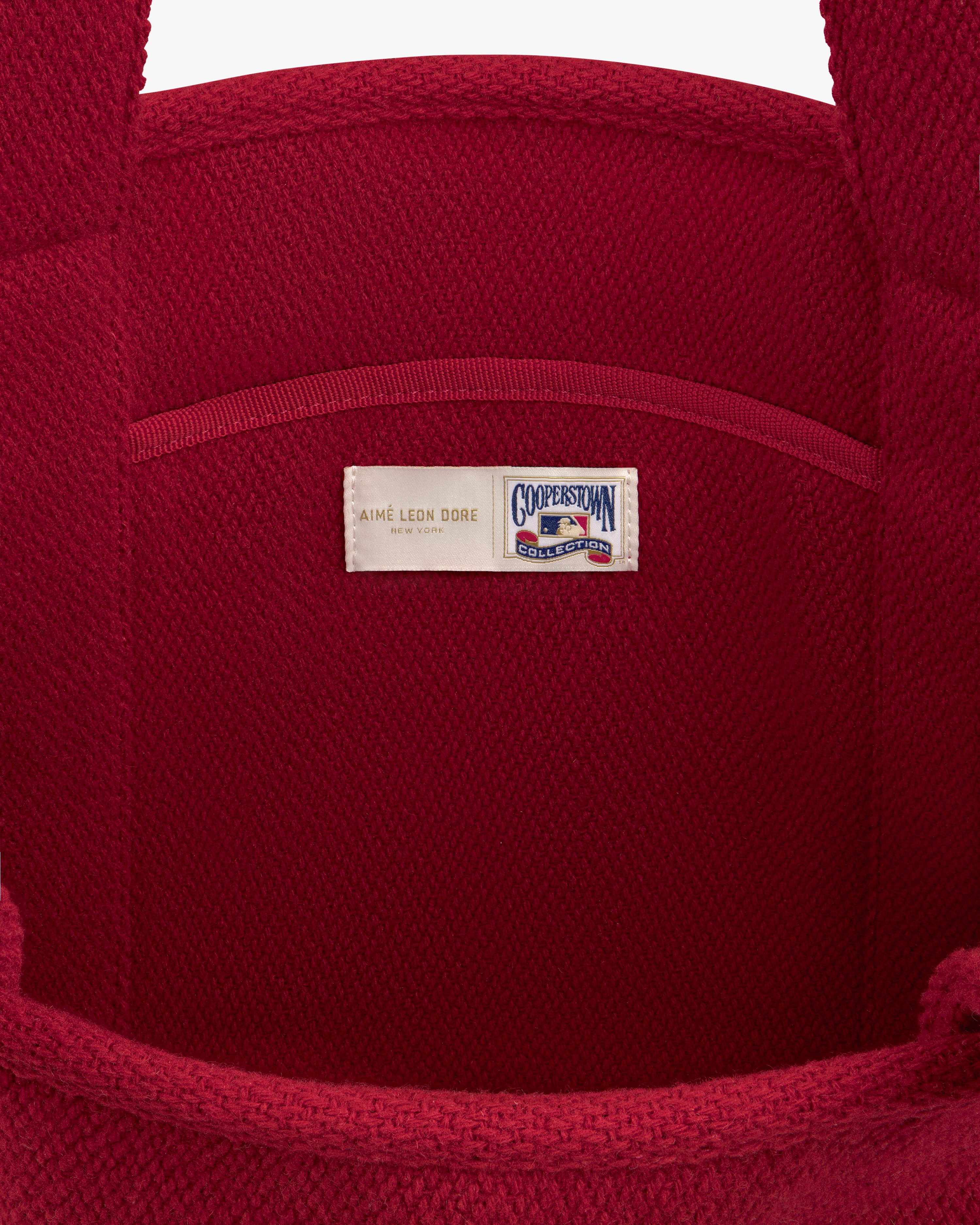 Interior of a red wool NY Highlanders Wool Tote Bag featuring a Cooperstown Collection label.