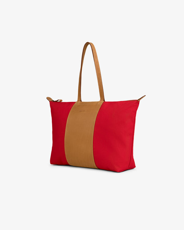 Leather Canvas Zip Tote in red and tan with long tan handles on a plain white background.