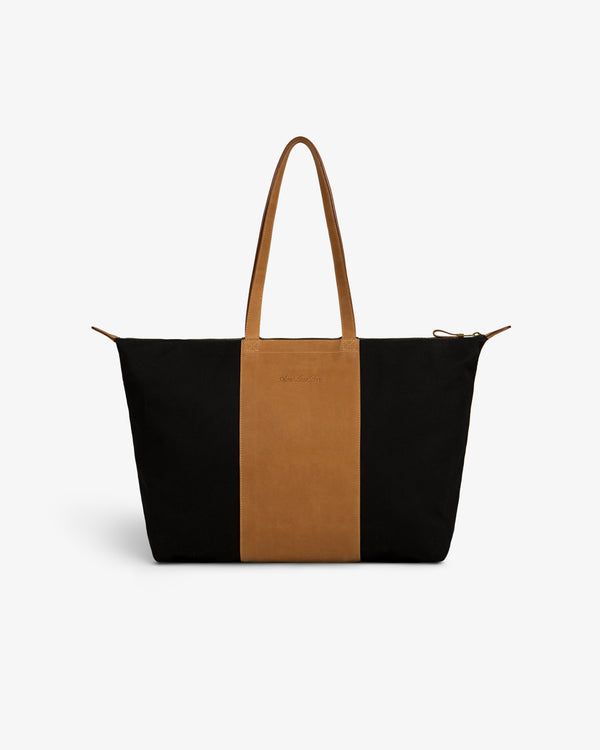 Leather Canvas Zip Tote in black and brown with two handles, displayed on a plain white background.