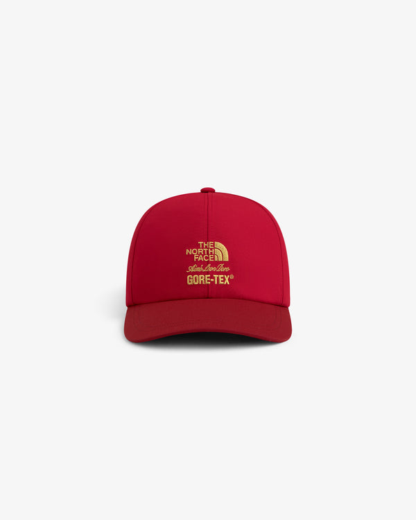 Front view of a red ALD/The North Face GORE-TEX Hat featuring yellow embroidered logo and text.