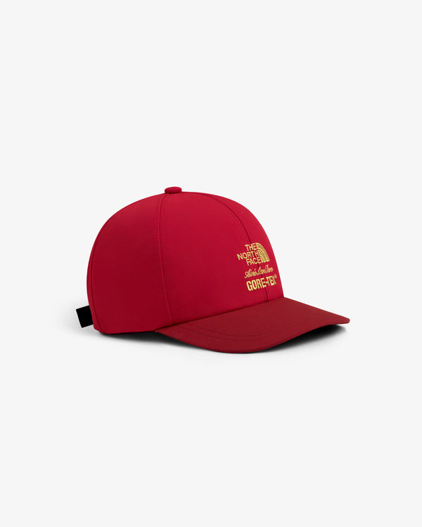 ALD / The North Face GORE-TEX Hat in red with yellow logo, shown at an angle on a white background.