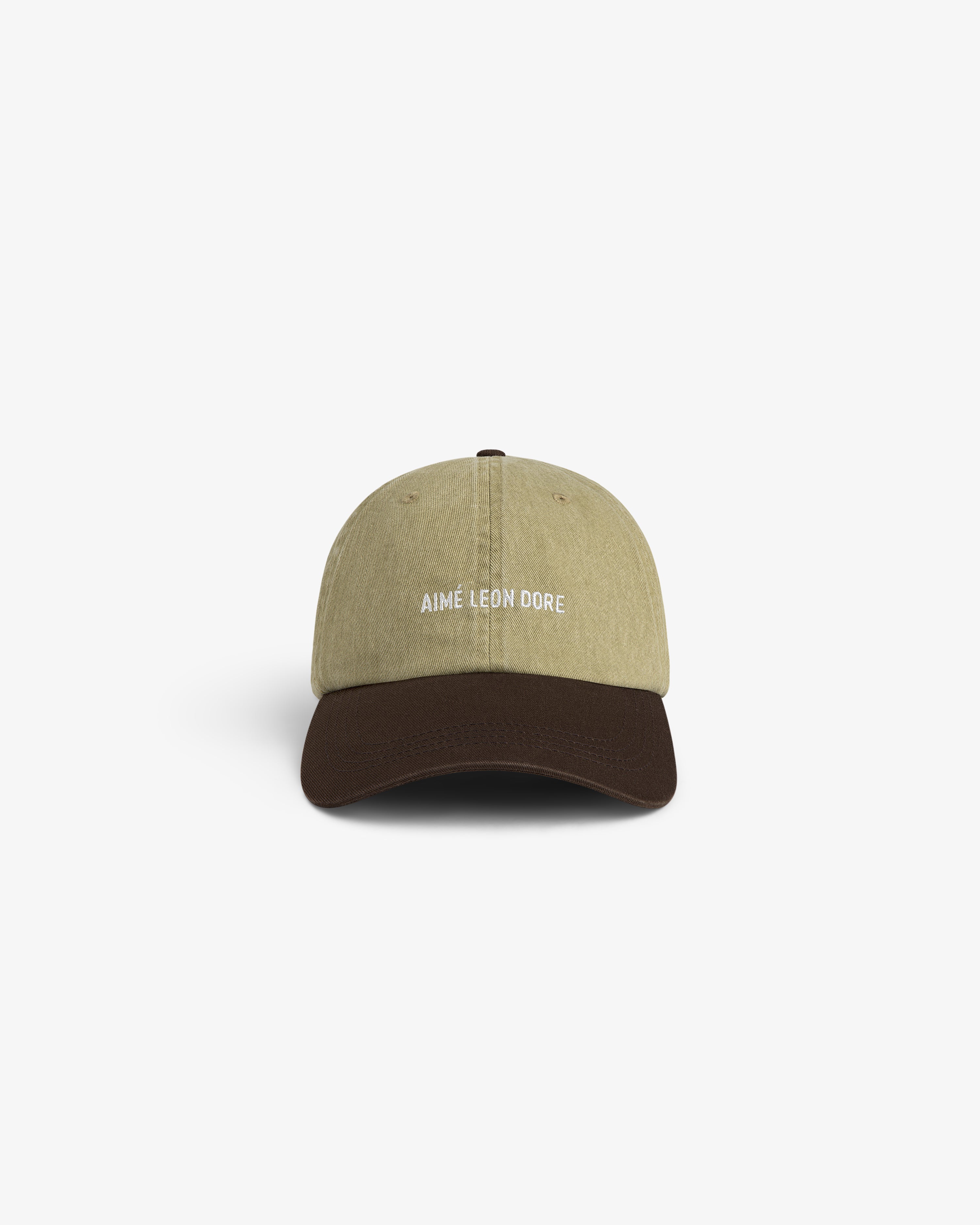 Pigment Dyed Logo Hat: khaki cap with dark brown brim, AIMÉ LEON DORE embroidered in white on the front.