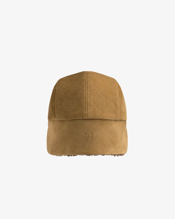 Tan suede Shearling Earflap Hat with fold-down earflaps and a small logo on the back.