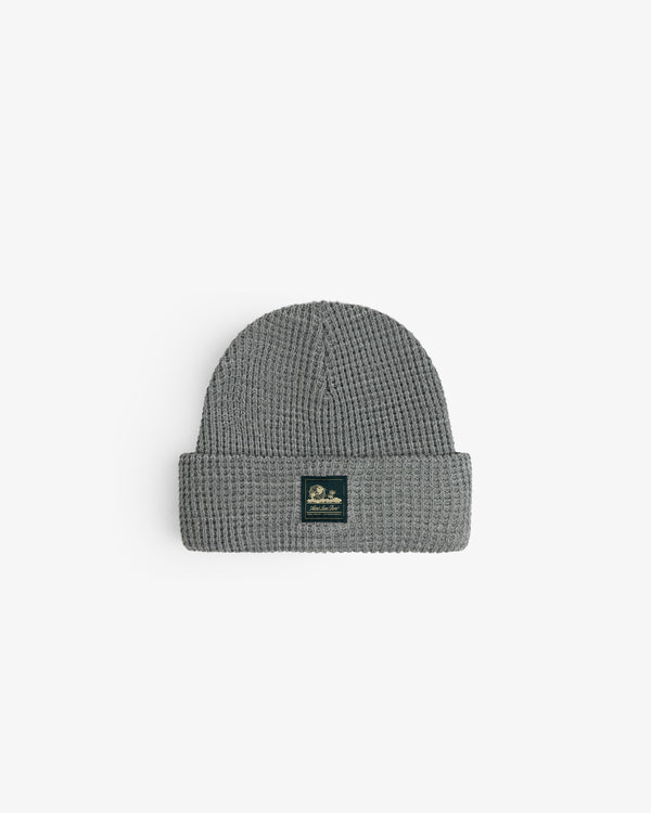 Waffle Knit Beanie in gray with folded brim and black front patch, displayed on a white background.