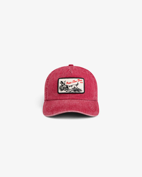 Red Aimé Retriever Hat featuring a rectangular patch with a hunting dog illustration and text.