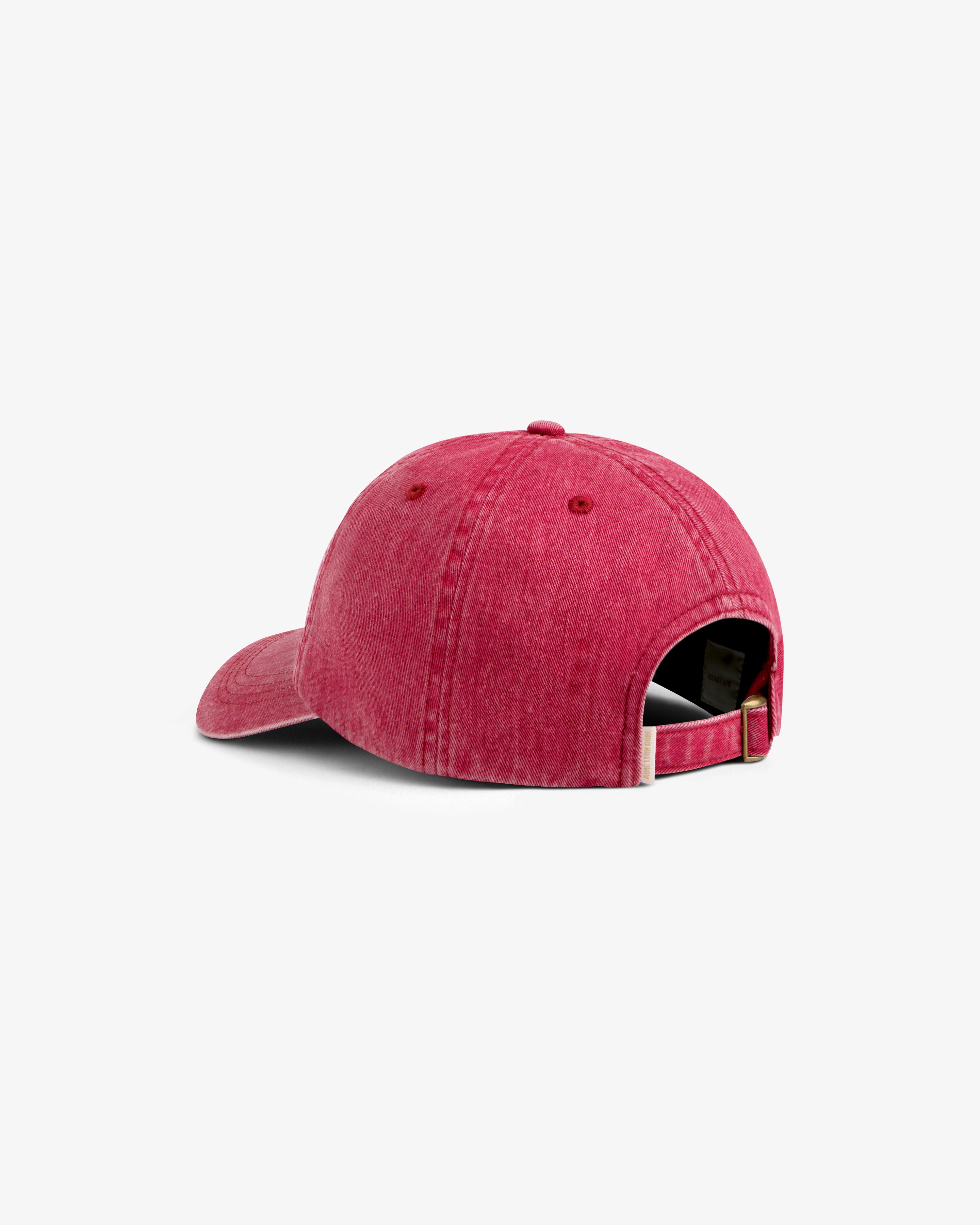 Aimé Retriever Hat in red, featuring an adjustable brass buckle strap at the back.
