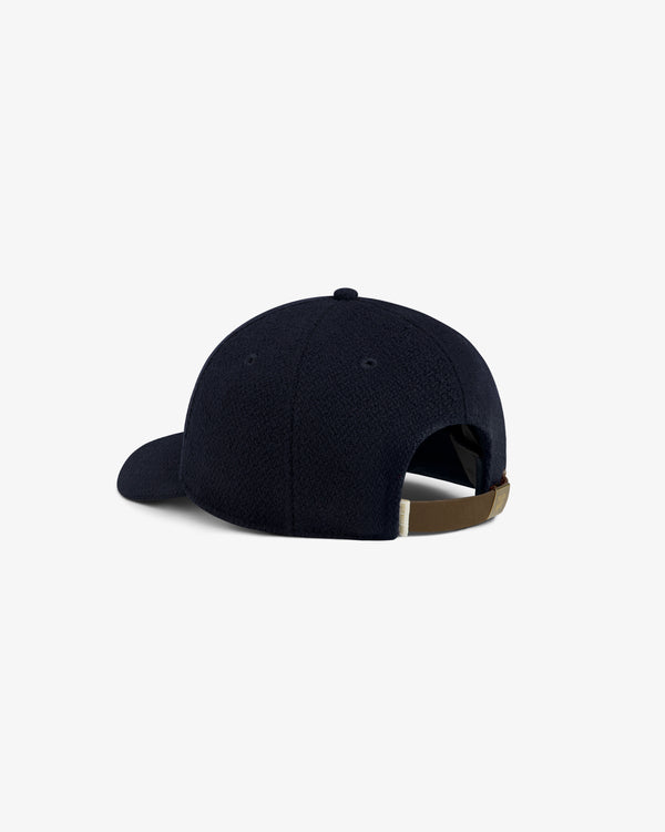 Rear view of a navy blue Wool Varsity Logo Hat with an adjustable brown strap.