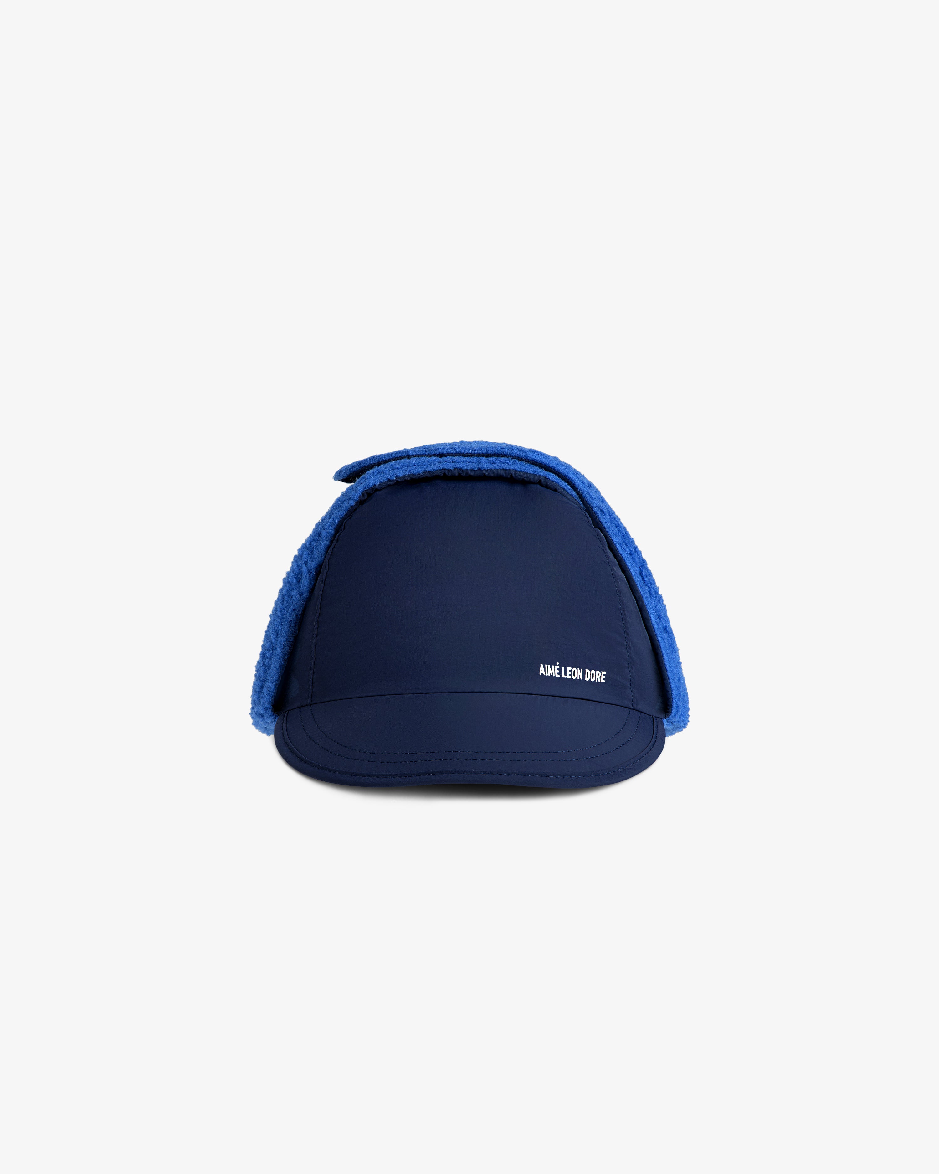 Fleece Lined Earflap Hat in navy blue with bright blue trim and a small white logo on the front.