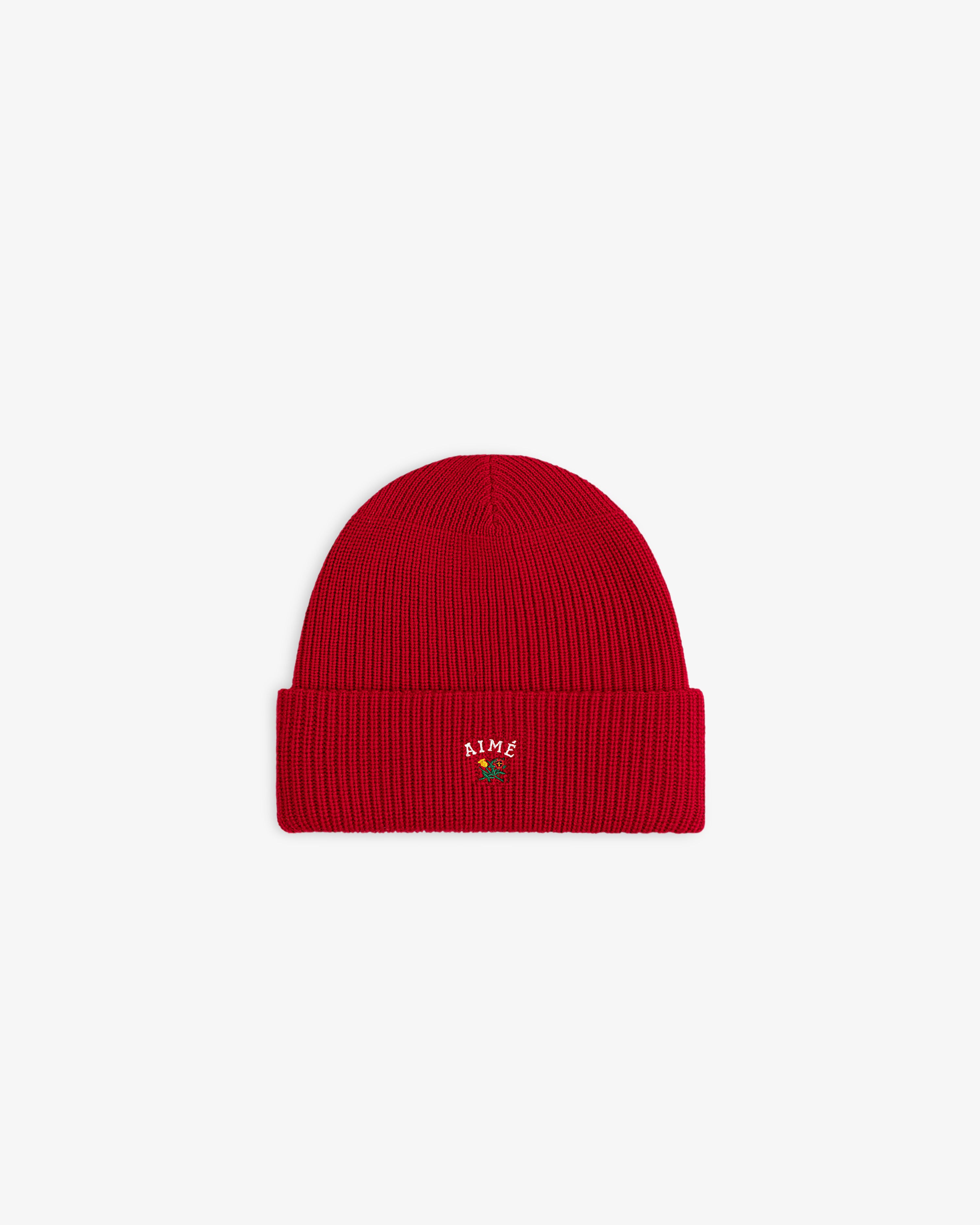 Crest Merino Wool Beanie in red with folded brim, embroidered text, and a rose at the front center.