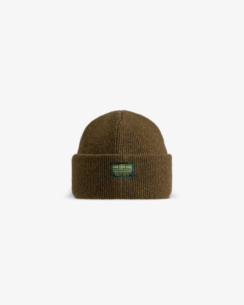 Olive green Wool Brim Beanie with a ribbed texture, a rolled brim, and a rectangular front patch.