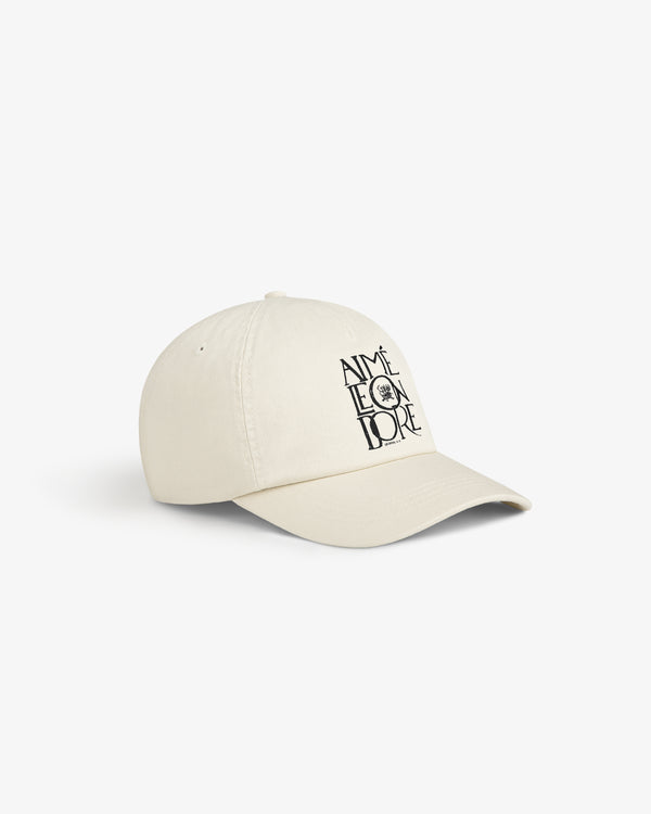 A beige Stacked Logo Hat with AIMÉ LEON DORE and a small black sun graphic printed on the front.