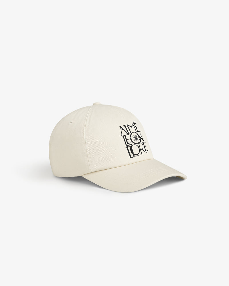 A beige Stacked Logo Hat with AIMÉ LEON DORE and a small black sun graphic printed on the front.