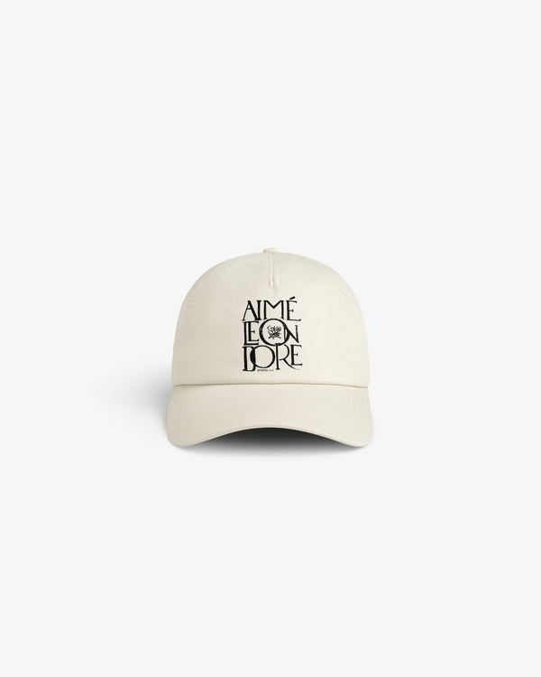 Beige Stacked Logo Hat with AIMÉ LEON DORE and black lion graphic embroidered on the front.