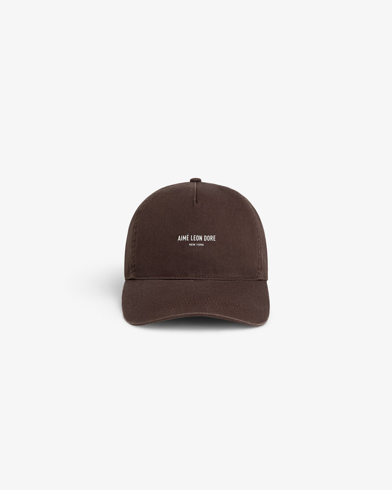 A brown Micro Logo Hat with white AIMÉ LEON DORE NEW YORK text on the front, shown on a white background.