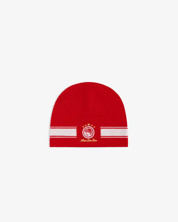 ALD / Olympiacos F.C. Stadium Beanie, a red beanie with a white horizontal stripe and a circular red and gold team emblem.