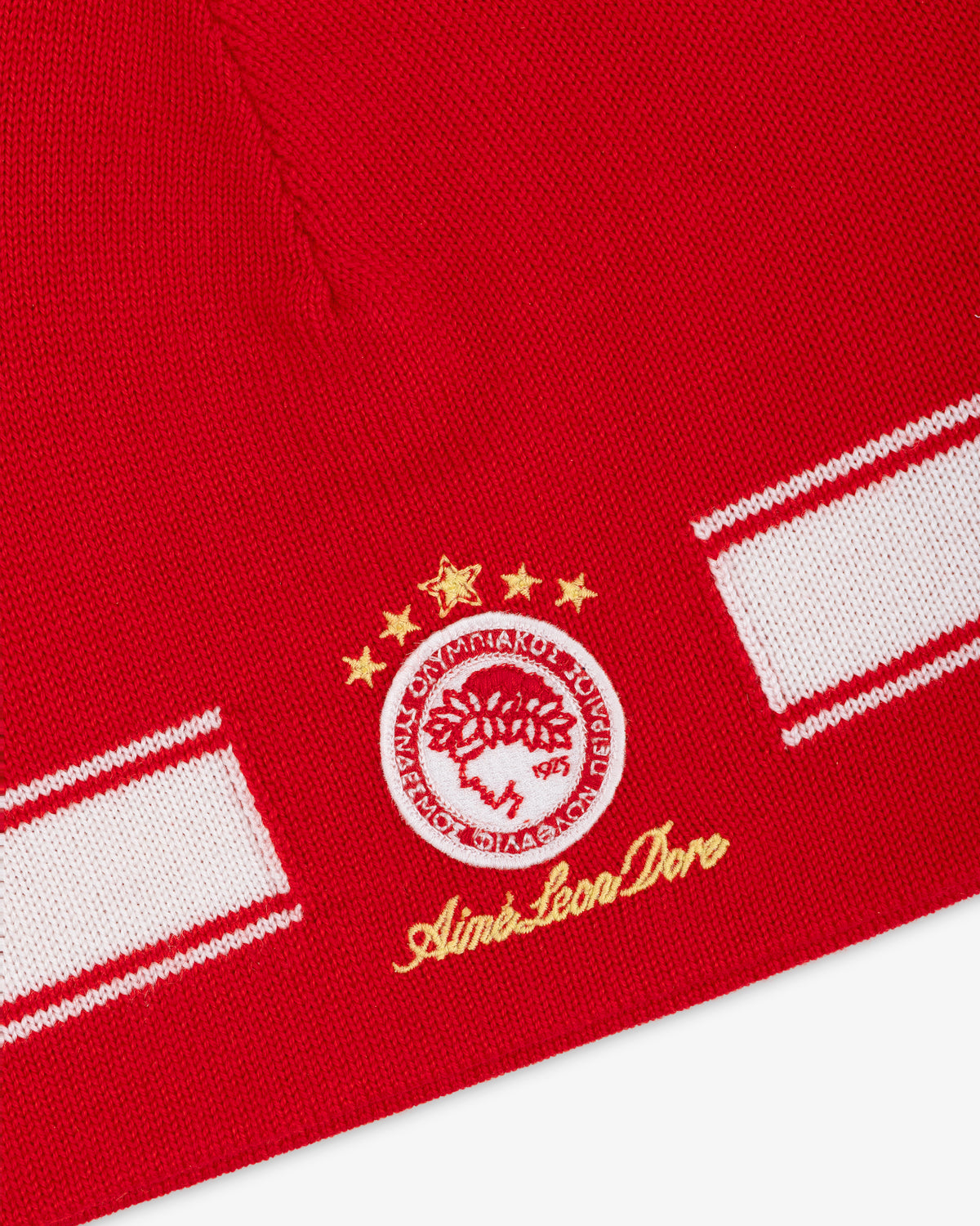 ALD / Olympiacos F.C. Stadium Beanie: red knit with a white stripe and a circular soccer crest with four gold stars.