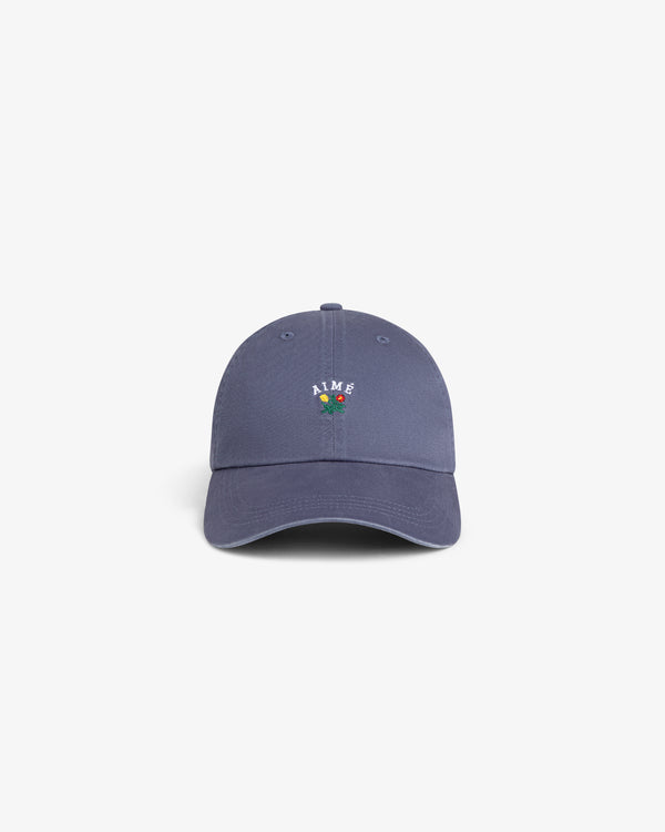 Crest Logo Hat in blue, features small embroidered flowers and “AIME” on front, shown on a white background.