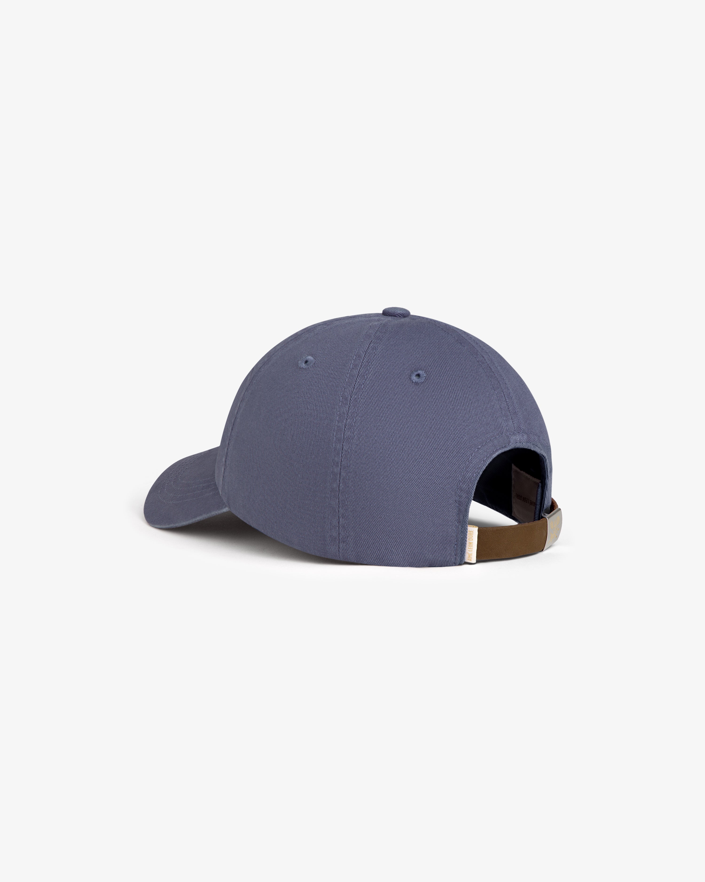 The Crest Logo Hat in blue, shown from the back, features an adjustable strap and a metal buckle.
