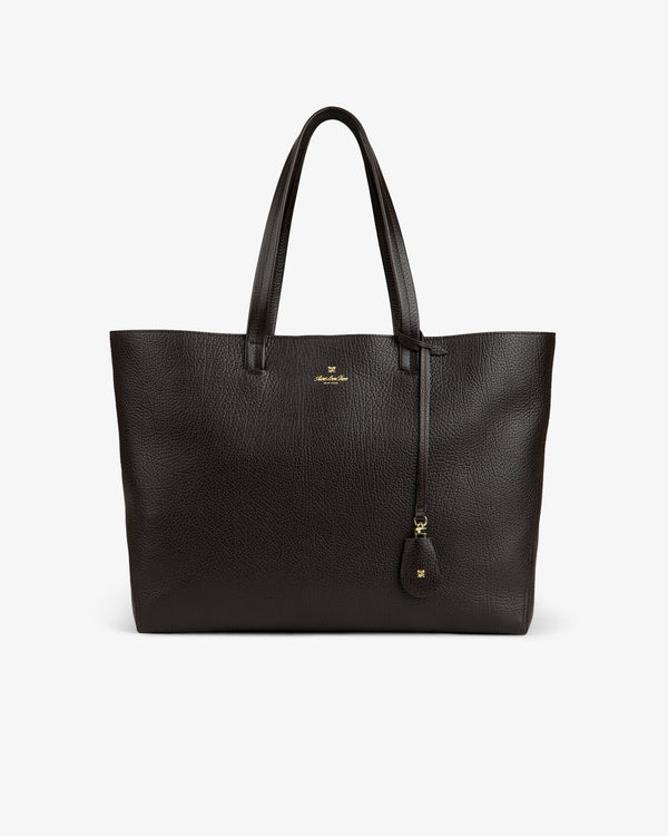 The Tumbled Leather Tote Bag is large, dark brown with two handles and a small gold logo on the front.