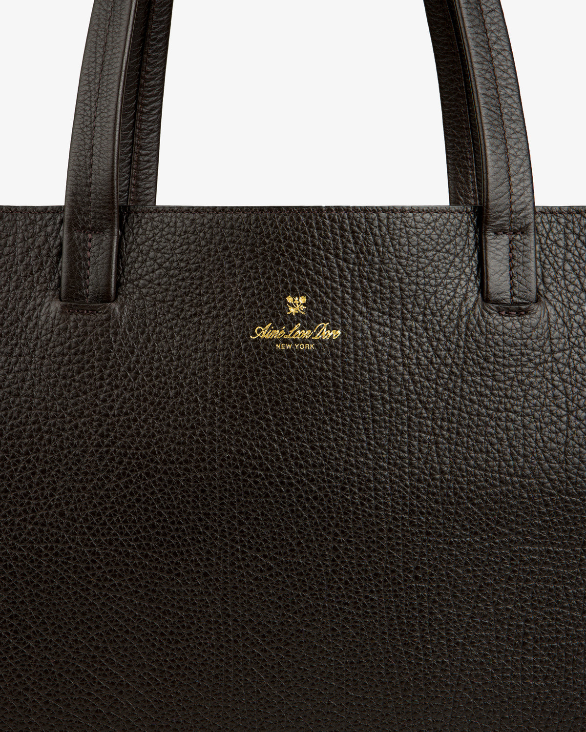 Close-up of a dark brown Tumbled Leather Tote Bag with gold Aspinal of London New York logo near the handle.