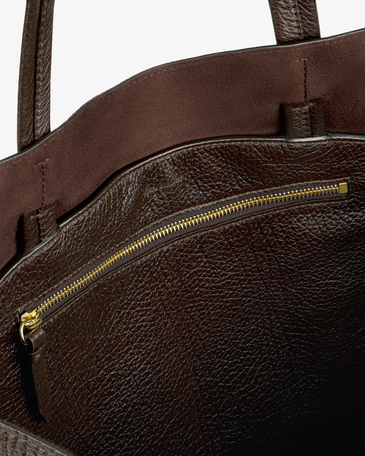 Close-up of the Tumbled Leather Tote Bag’s brown interior, gold zipper pocket, and dual handles.