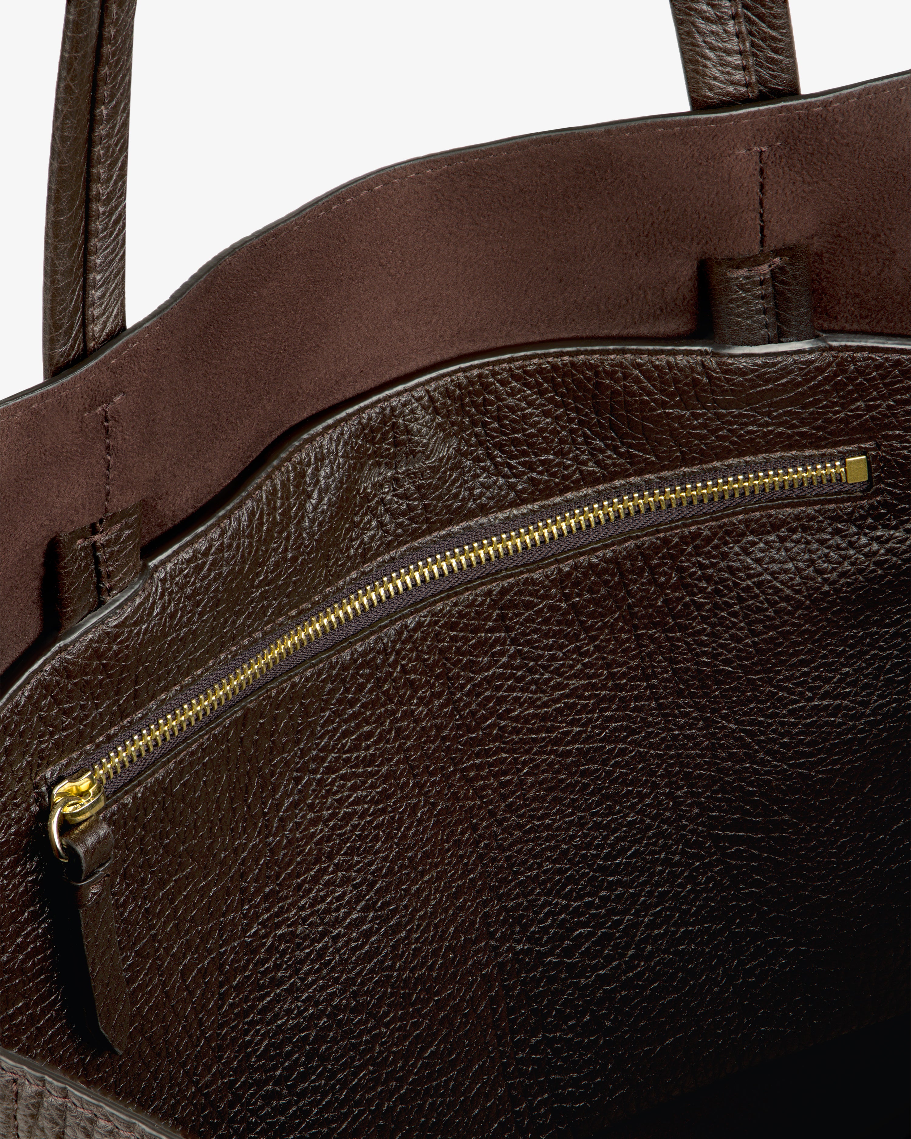 Close-up of the Tumbled Leather Tote Bag’s brown interior, gold zipper pocket, and dual handles.