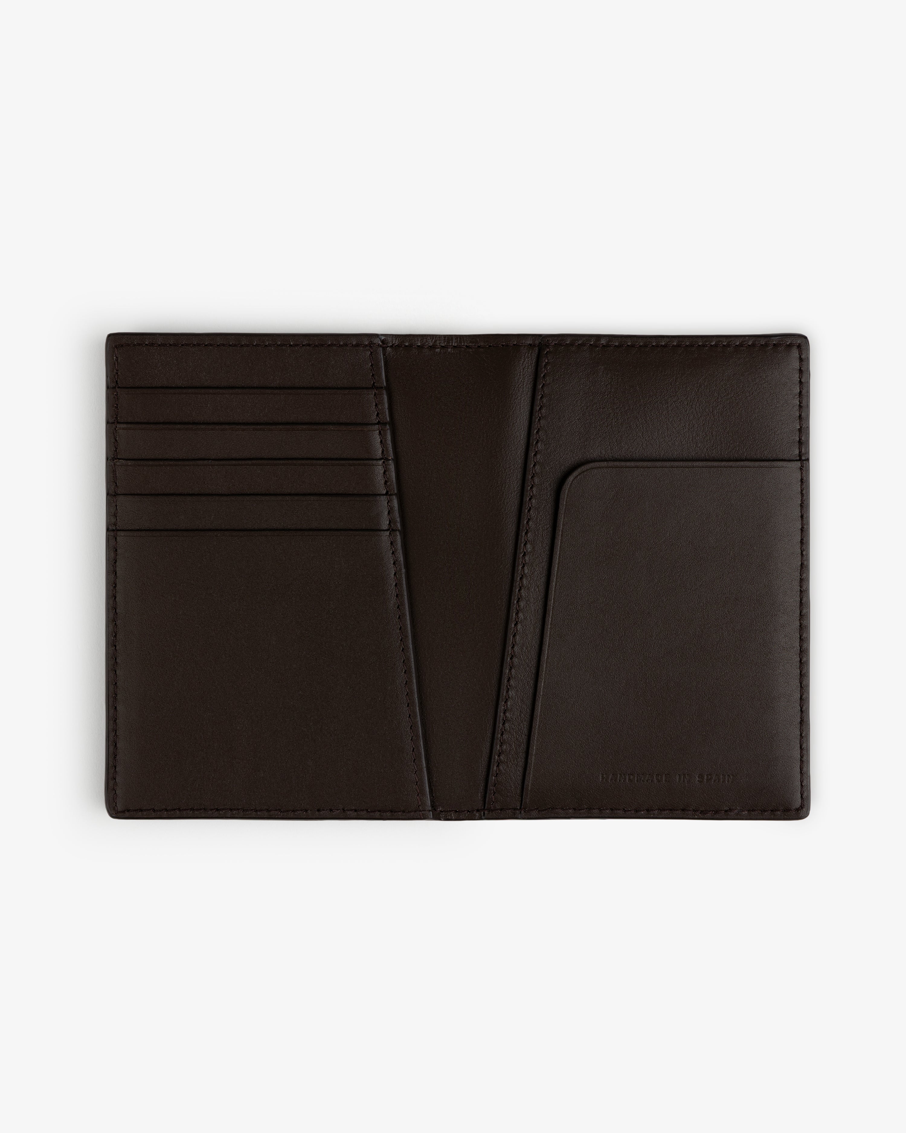 The Tumbled Leather Passport Holder in dark brown, with card slots and pocket, displayed on a white background.