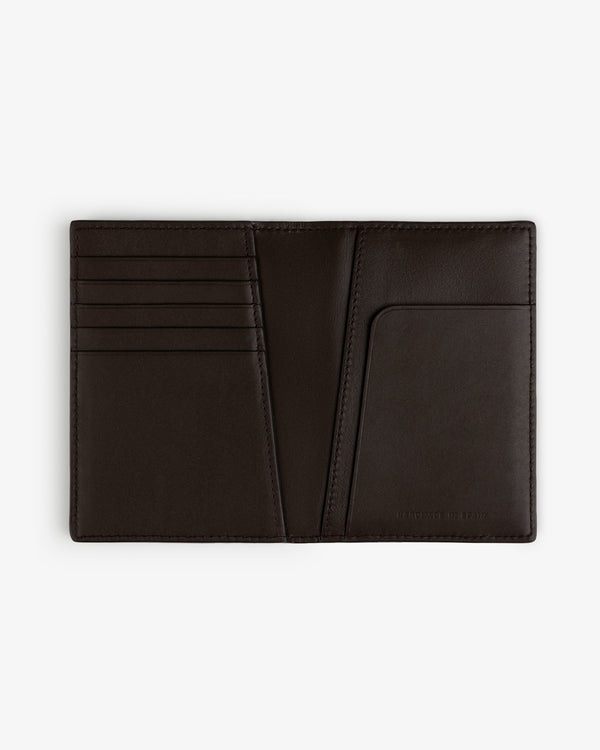 The Tumbled Leather Passport Holder in dark brown, with card slots and pocket, displayed on a white background.