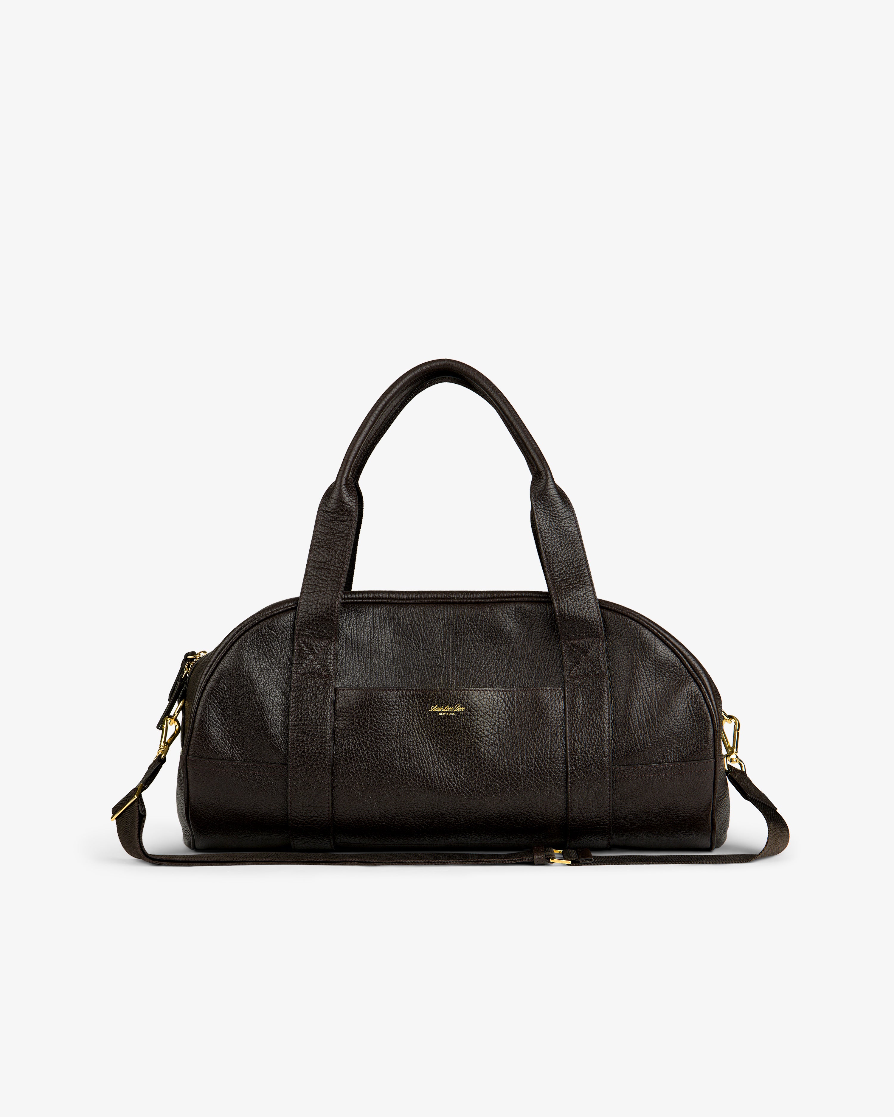 Tumbled Leather Duffle in dark brown with gold hardware, dual handles, and detachable strap on a white background.