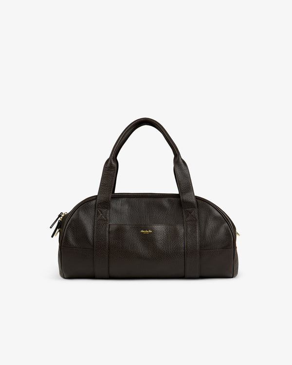 Tumbled Leather Duffle in dark brown with dual handles, gold zippers, and a small gold front logo.