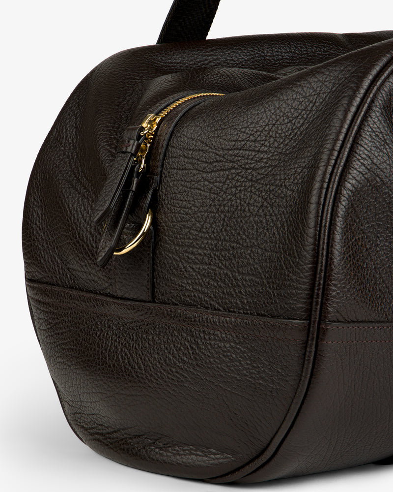 Close-up of the Tumbled Leather Duffle in dark brown with textured leather, gold zipper, and visible stitching.