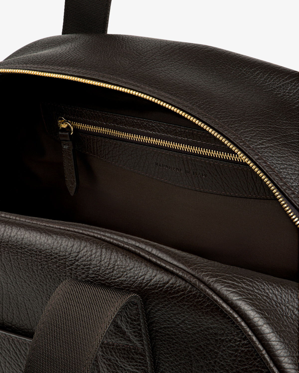 Close-up of the Tumbled Leather Duffle, open to reveal a zippered inner pocket with gold zipper detail.