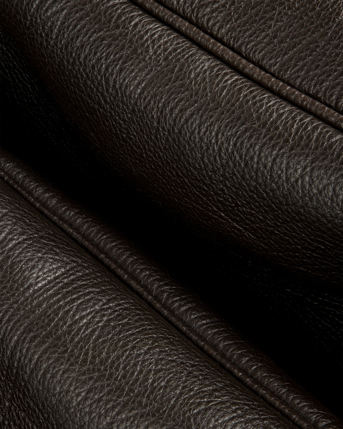 Close-up of Tumbled Leather Duffle in dark brown, showing its textured grain and detailed stitching.