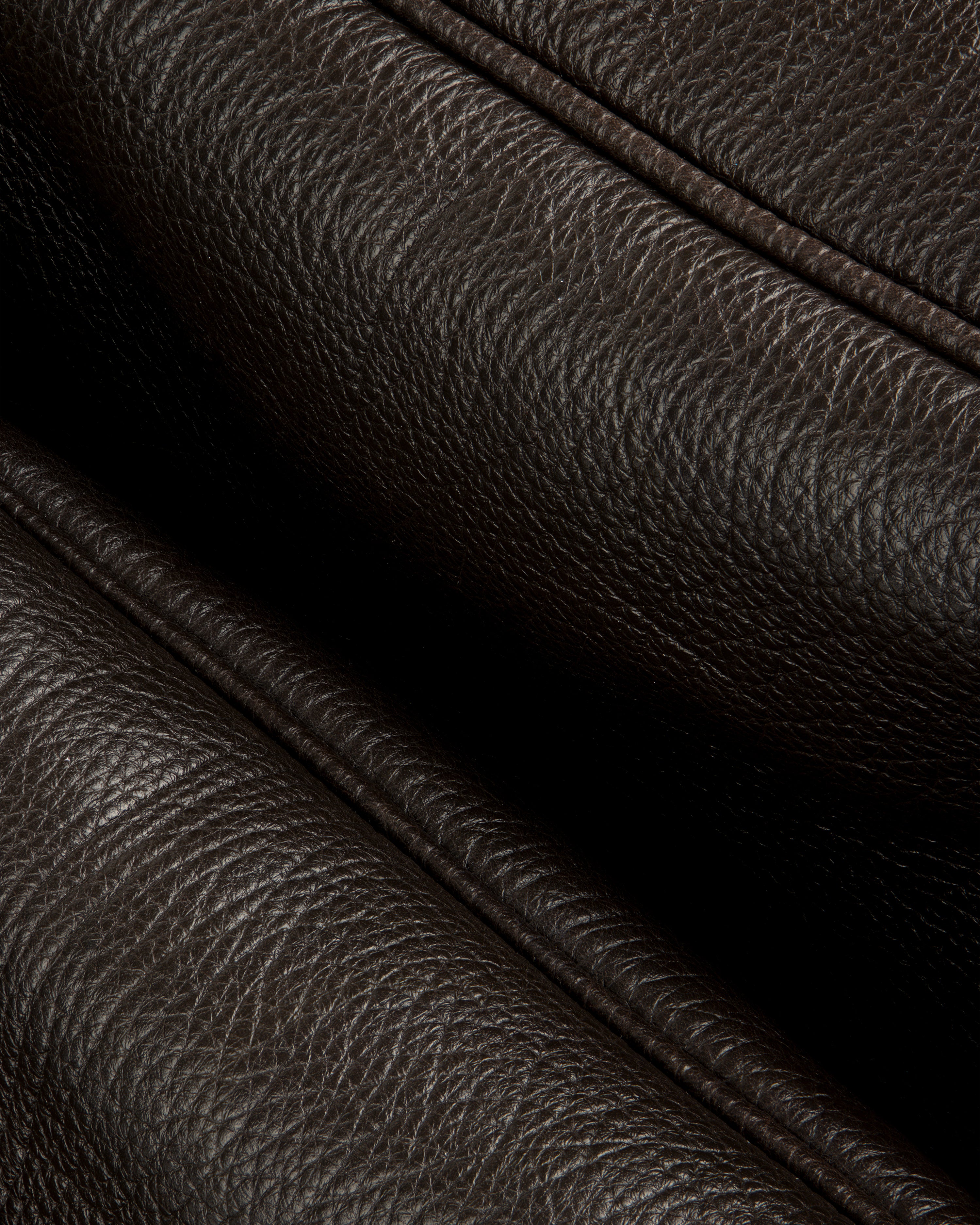 Close-up of Tumbled Leather Duffle in dark brown, showing its textured grain and detailed stitching.