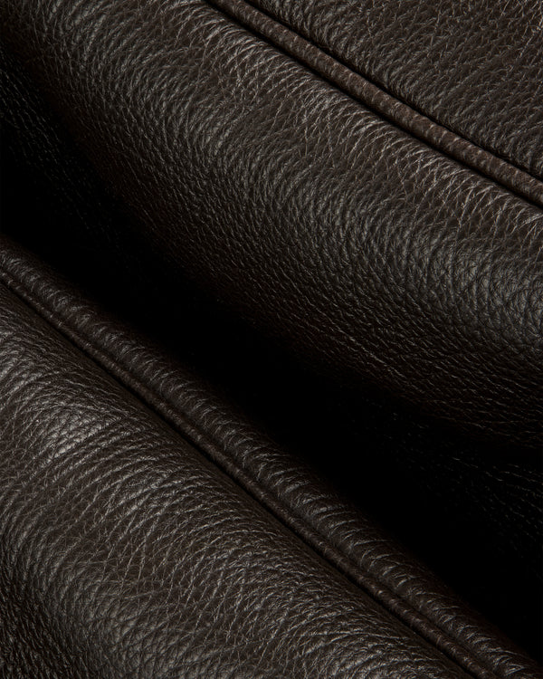 Close-up of Tumbled Leather Duffle in dark brown, showing its textured grain and detailed stitching.