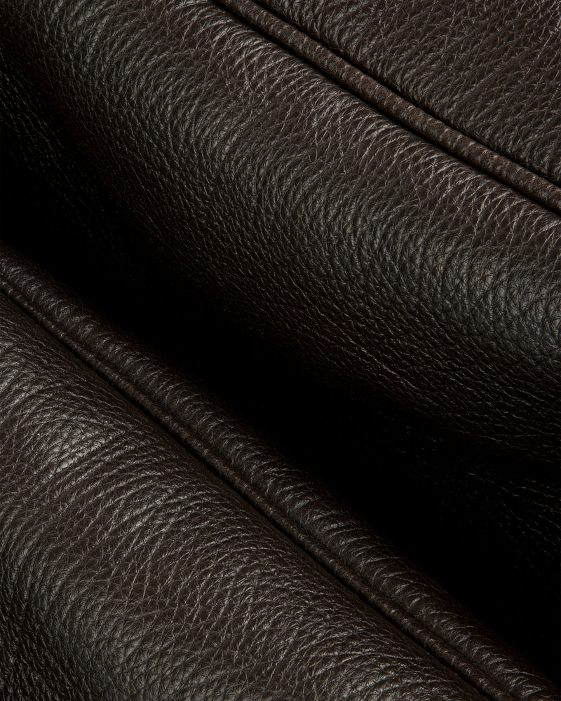 Close-up of Tumbled Leather Duffle in dark brown, showing its textured grain and detailed stitching.