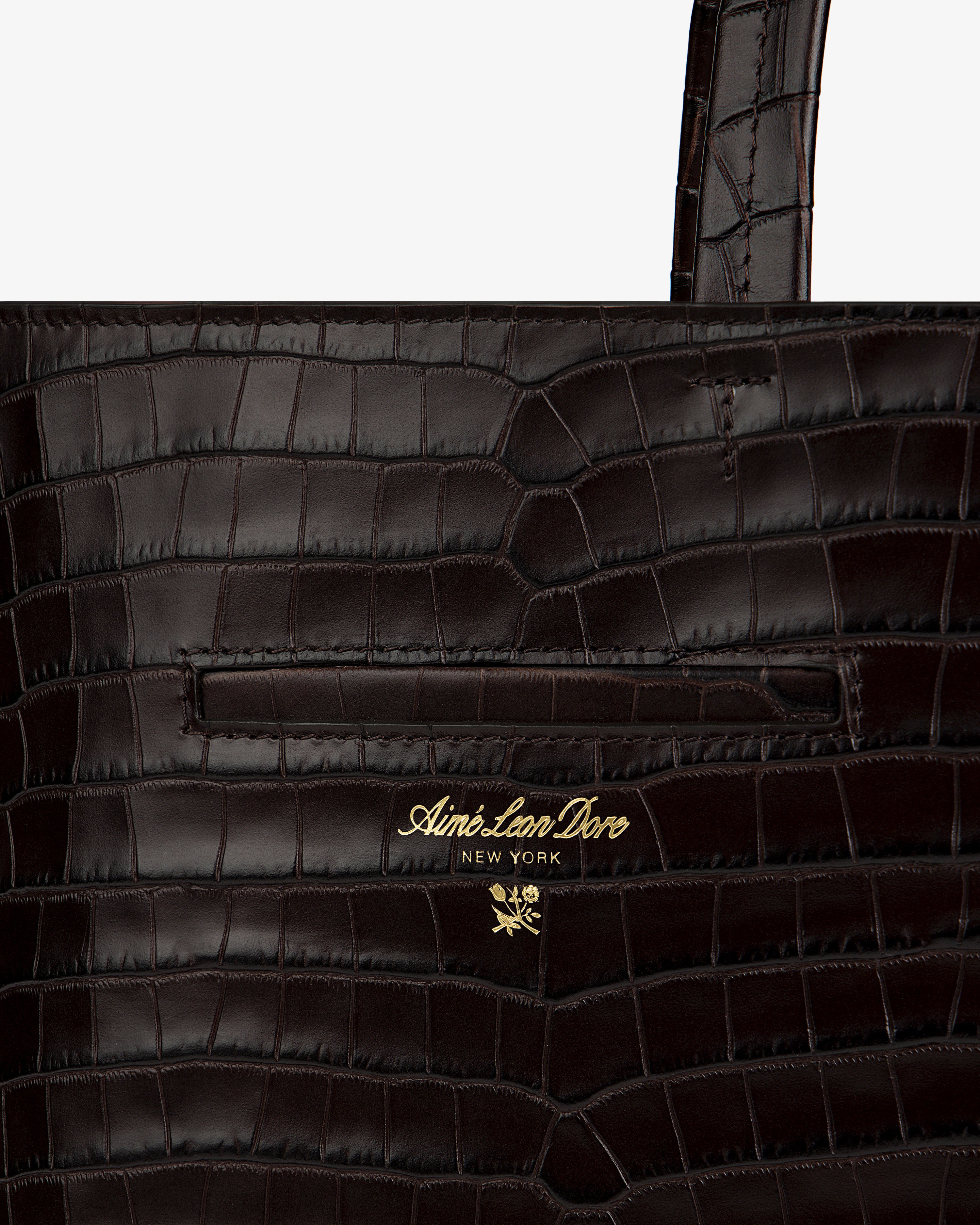 Dark brown croc-embossed leather shoulder bag with a gold-tone brand logo and floral emblem.