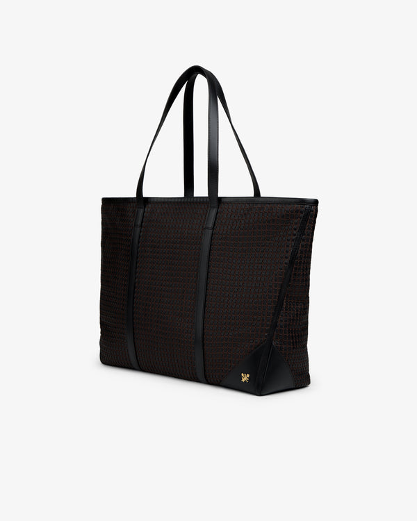 Black woven leather tote bag with two shoulder straps and a gold logo emblem.