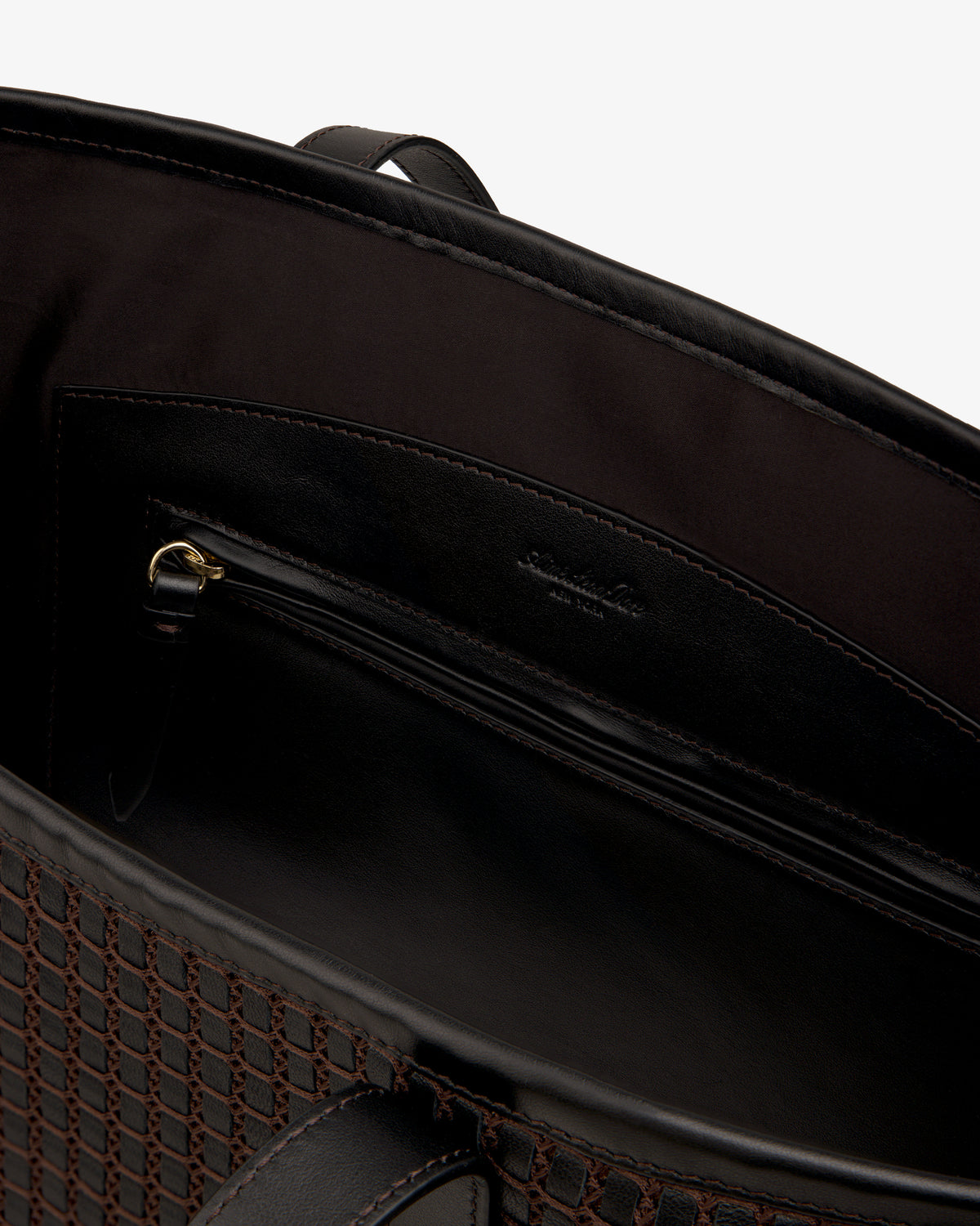 Interior view of a dark Woven Leather Tote Bag showing a zippered pocket.