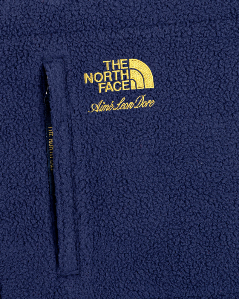 Navy blue ALD/The North Face packable fleece blanket with zip pocket and yellow embroidered logo.