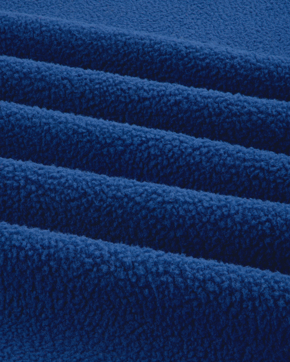 Close-up of ALD / The North Face Denali Fleece Scarf shows soft blue fabric with textured surface and parallel folds.