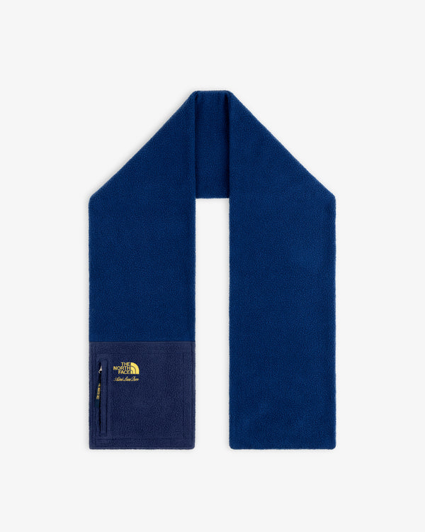 ALD / The North Face Denali fleece scarf in blue with zippered pocket and yellow logo on one end, shown on white.